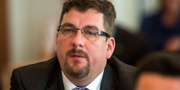 Gesicht von Holger Arppe, mit dunklen Haaren, leichtem Bart und einer Brille Gesicht von Holger Arppe, mit dunklen Haaren, leichtem Bart und einer Brille