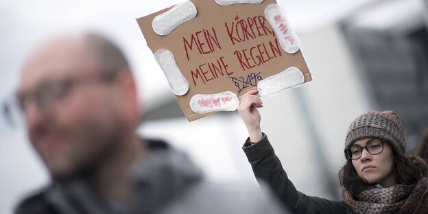 Paragraf 219a: Eine Frau demonstriert mit einem Schild auf dem steht: Mein Körper meine Regeln Paragraf 219a: Eine Frau demonstriert mit einem Schild auf dem steht: Mein Körper meine Regeln