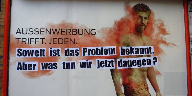 Werbeplakat mit der Aufschrift "Aussenwerbung trifft jeden", darunter aufgeklebte Zettel mit der Aufschrift "Soweit ist das Problem bekannt. Aber was tun wir jetzt dagegen?"