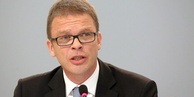 Der Chef der Deutschen Bank, Christian Sewing, sitzt mit Anzug und Krawatte hinter einem Mikrofon Der Chef der Deutschen Bank, Christian Sewing, sitzt mit Anzug und Krawatte hinter einem Mikrofon