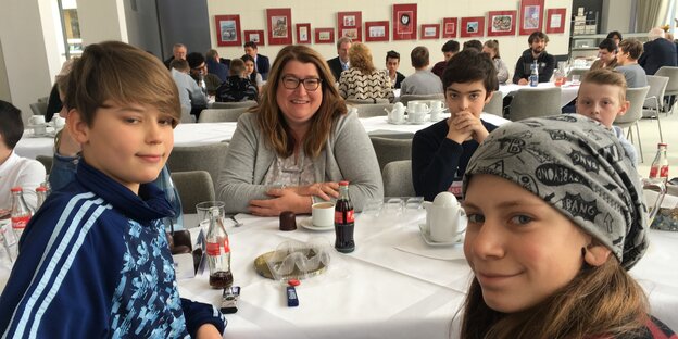 Bremens Sozialsenatorin Anja Stahmann sitzt mit Schülern an einem Tisch. Bremens Sozialsenatorin Anja Stahmann sitzt mit Schülern an einem Tisch.
