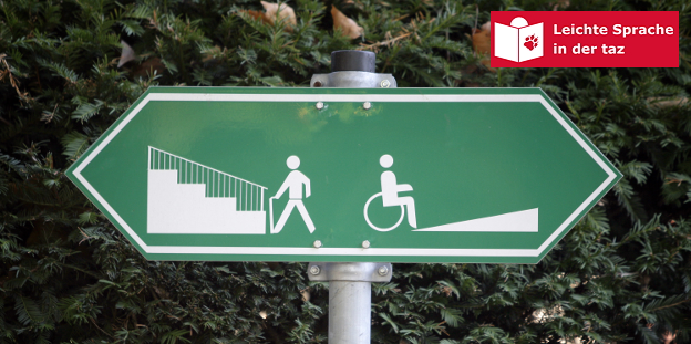 Ein Schild, links ist jemand vor einer Treppe, rechts ist jemand vor einer Rollstuhlrampe abgebildet, Treppe und Rampe führen in unterschiedliche Richtungen Ein Schild, links ist jemand vor einer Treppe, rechts ist jemand vor einer Rollstuhlrampe abgebildet, Treppe und Rampe führen in unterschiedliche Richtungen