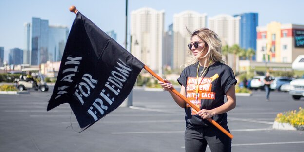 Eine Frau hält eine schwarze Flagge auf der Freedom steht Eine Frau hält eine schwarze Flagge auf der Freedom steht