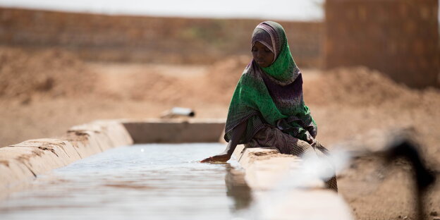 Frau sitzt am Rand eines Wasserbeckens in Äthiopien Frau sitzt am Rand eines Wasserbeckens in Äthiopien