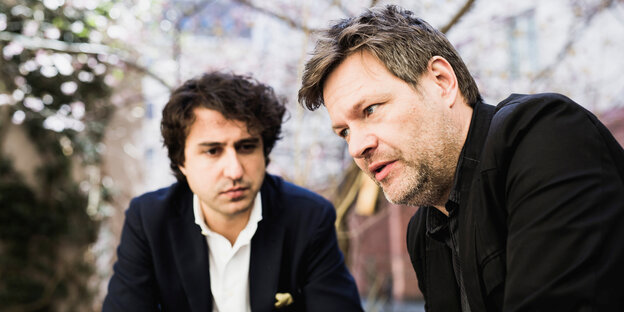 Jesse Klever beugt sich zu Robert Habeck, der sinnierend in die Luft starrt Jesse Klever beugt sich zu Robert Habeck, der sinnierend in die Luft starrt