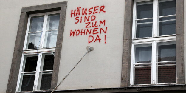 Haus mit Schriftzug "Häuser sind zum Wohnen da"