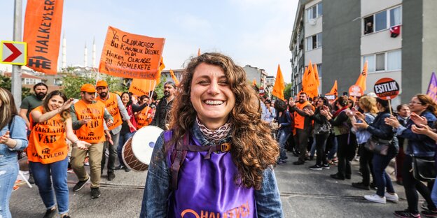 Frau, hinter ihr Demonstrierende Frau, hinter ihr Demonstrierende
