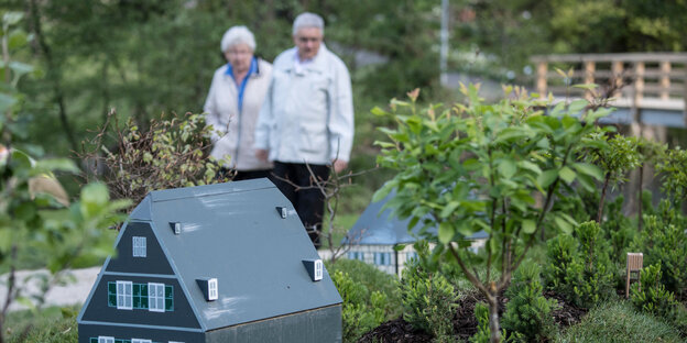 Senioren mit Miniaturhäuschen Senioren mit Miniaturhäuschen