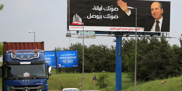 Lkws fahren an einem Wahlplakat für den ehemaligen libanesischen General Jamil al-Sayyed vorbei Lkws fahren an einem Wahlplakat für den ehemaligen libanesischen General Jamil al-Sayyed vorbei