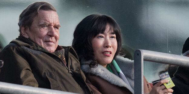Gerhard Schröder mit seiner Partnerin Kim So Yeon auf einer Stadiontribüne Gerhard Schröder mit seiner Partnerin Kim So Yeon auf einer Stadiontribüne