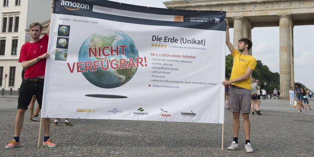 Zwei Aktivisten halten Schild mit Aufschrift "Erde nicht verfügbar" vorm Brandenburger Tor hoch Zwei Aktivisten halten Schild mit Aufschrift "Erde nicht verfügbar" vorm Brandenburger Tor hoch