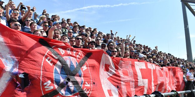 Löwenfans mit einem Schmähtransparent gegen den FC Bayern Löwenfans mit einem Schmähtransparent gegen den FC Bayern