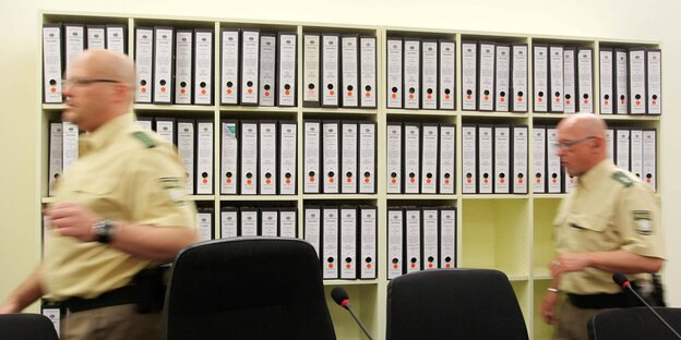 Zwei Polizisten vor ganz vielen Aktenordnern Zwei Polizisten vor ganz vielen Aktenordnern