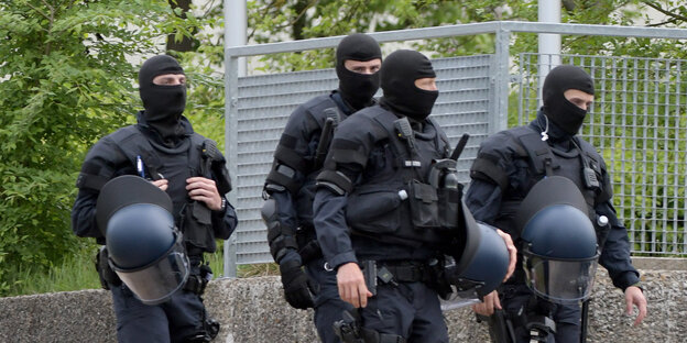Polizisten vor einem Zaun Polizisten vor einem Zaun