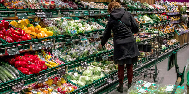 Kundin vor Gemüseregal im Supermarkt Kundin vor Gemüseregal im Supermarkt