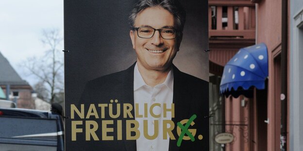 Ein Wahlplakat mit lachendem Mann darauf Ein Wahlplakat mit lachendem Mann darauf