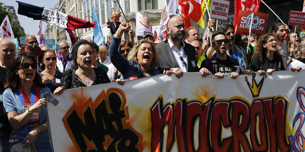 05.05.2018, Frankreich, Paris: Demonstranten tragen bei einer Protestveranstaltung ein Banner.