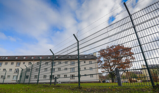 ein Gebäude hinter einem Stacheldrahtzaun ein Gebäude hinter einem Stacheldrahtzaun