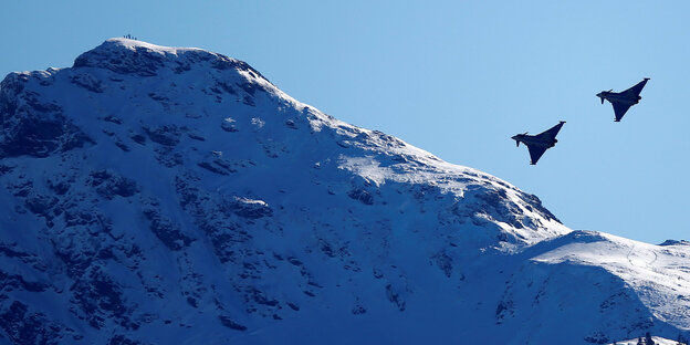 Zwei Kampfjets umfliegen eine Bergspitze. Zwei Kampfjets umfliegen eine Bergspitze.