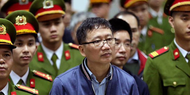 Trinh Xuan Thanh umringt von Uniform tragenden Männern Trinh Xuan Thanh umringt von Uniform tragenden Männern