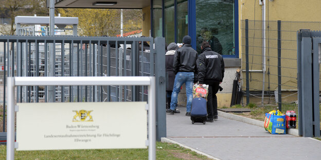 Sicherheitsmitarbeiter und Bewohner am Eingang der Unterkunft von Ellwangen Sicherheitsmitarbeiter und Bewohner am Eingang der Unterkunft von Ellwangen