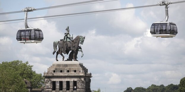 Das Kaiser-Wilhelm-Denkmal am Deutschen EcK, darüber schweben die Kabinen einer Seilbahn Das Kaiser-Wilhelm-Denkmal am Deutschen EcK, darüber schweben die Kabinen einer Seilbahn