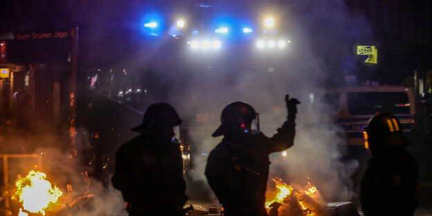 Polizisten stehen vor einem Feuer Polizisten stehen vor einem Feuer