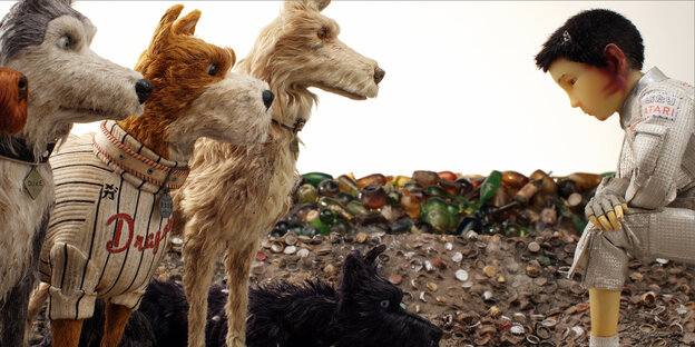 Die Hunde von Isle of Dogs stehen dem kienden menschlichen Protagonisten gegenüber Die Hunde von Isle of Dogs stehen dem kienden menschlichen Protagonisten gegenüber