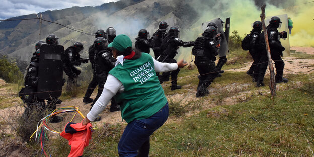 Eine Aktivistin wehrt sich gegen eine Reihe Polizisten Eine Aktivistin wehrt sich gegen eine Reihe Polizisten