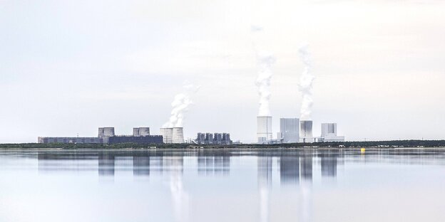 Ein Kohlekraftwerk mit rauchenden Schloten ist auf der anderen Seite eines Sees zu sehen Ein Kohlekraftwerk mit rauchenden Schloten ist auf der anderen Seite eines Sees zu sehen