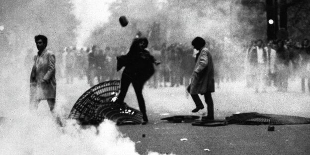 Proteste in Paris im Mai 1968, eine Frau wirft einen Stein Proteste in Paris im Mai 1968, eine Frau wirft einen Stein