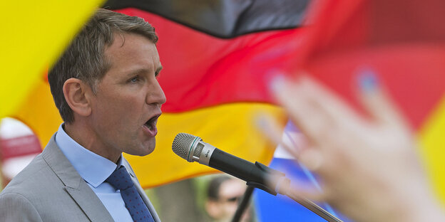 Björn Höcke schreit vor Deutschlandfahne in ein Mikrofon Björn Höcke schreit vor Deutschlandfahne in ein Mikrofon