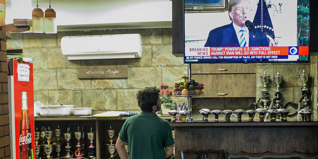 Ein Gast eines Teehauses verfolgt die Erklärung von US-Präsident Donald Trump zum Ausstieg der USA aus dem Atomabkommen im Fernsehen Ein Gast eines Teehauses verfolgt die Erklärung von US-Präsident Donald Trump zum Ausstieg der USA aus dem Atomabkommen im Fernsehen