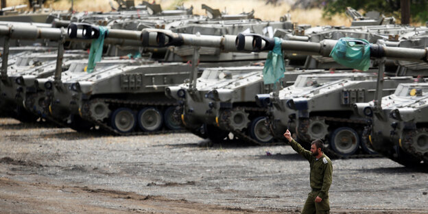 Ein israelischer Soldat steht vor einer Reihe von Panzern in den Golanhöhen Ein israelischer Soldat steht vor einer Reihe von Panzern in den Golanhöhen