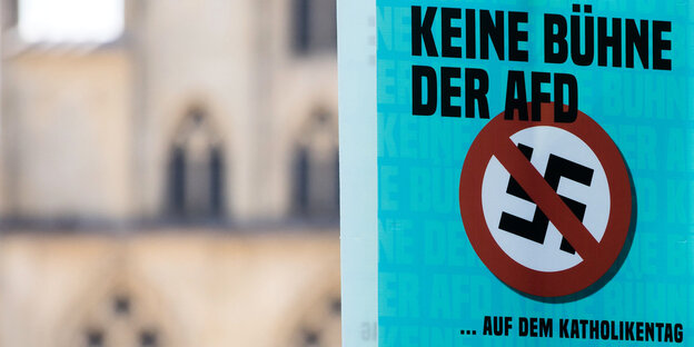 Ein Plakat hängt in einer Stadt, darauf ist ein durchgestrichenes Hakenkreuz zu sehen. Auf dem Plakat steht: Keine Bühne für die AfD auf dem Katholikentag Ein Plakat hängt in einer Stadt, darauf ist ein durchgestrichenes Hakenkreuz zu sehen. Auf dem Plakat steht: Keine Bühne für die AfD auf dem Katholikentag