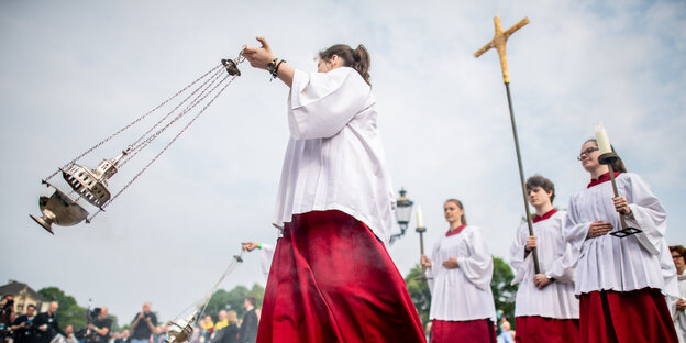 Messdiener tragen ein Weihrauchfass und ein Kreuz Messdiener tragen ein Weihrauchfass und ein Kreuz