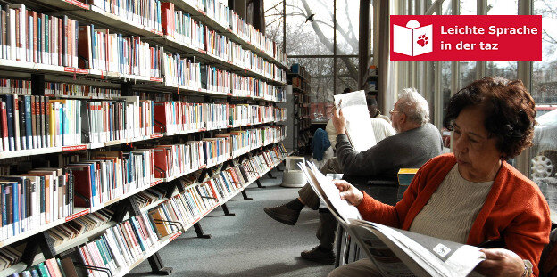 Zwei Menschen sitzen in einer Bücherei und lesen, neben ihnen steht ein Bücherregal Zwei Menschen sitzen in einer Bücherei und lesen, neben ihnen steht ein Bücherregal