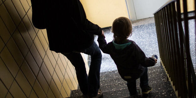 Eine Frau führt ein Kind eine Treppe hinunter. Eine Frau führt ein Kind eine Treppe hinunter.