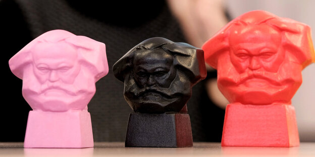 Drei kleine Pastiken in pink, schwarz und rot, die alle den Kopf von Karl Marx zeigen Drei kleine Pastiken in pink, schwarz und rot, die alle den Kopf von Karl Marx zeigen