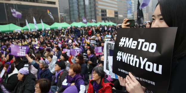 Eine Frau hält ein Schild, auf dem „#MeToo" und „#WithYou“ stehen Eine Frau hält ein Schild, auf dem „#MeToo" und „#WithYou“ stehen