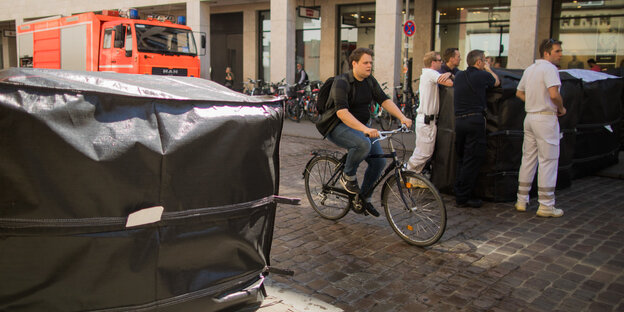 Blöcke aus Beton sperren eine Straße für Autos und Lkw ab, eine Radfahrerin kommt aber durch Blöcke aus Beton sperren eine Straße für Autos und Lkw ab, eine Radfahrerin kommt aber durch