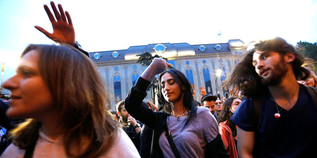 DemonstrantInnen, die unter freiem Himmel im Abendlicht tanzen