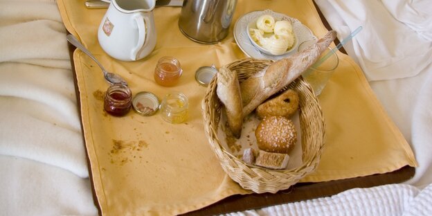 Tabeltt mit Frühstückszutaten auf einem Bett Tabeltt mit Frühstückszutaten auf einem Bett