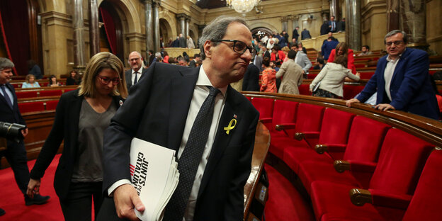 Quim Torra biegt um die Ecke. Er hält Papiere unterm Arm und hat gerötete Backen Quim Torra biegt um die Ecke. Er hält Papiere unterm Arm und hat gerötete Backen