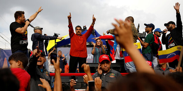 Maduro mit erhobenen Armen vor einer Menschenmenge Maduro mit erhobenen Armen vor einer Menschenmenge