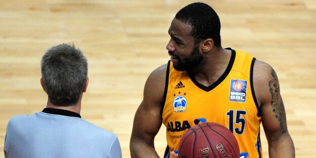 Ein Basketballspieler und ein Schiedsrichter sprechen miteinander Ein Basketballspieler und ein Schiedsrichter sprechen miteinander
