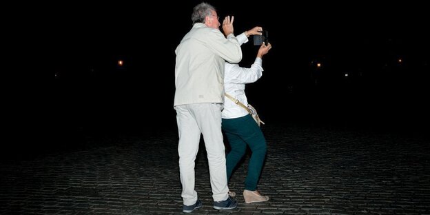 Zwei Menschen fotografieren im Dunkeln Zwei Menschen fotografieren im Dunkeln