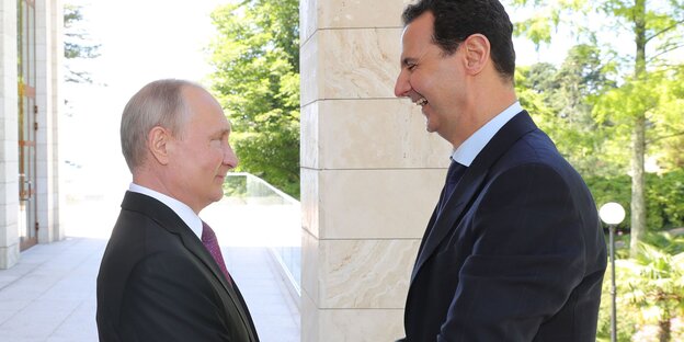 Putin und Assad stehe sich gegenüber und lächeln Putin und Assad stehe sich gegenüber und lächeln
