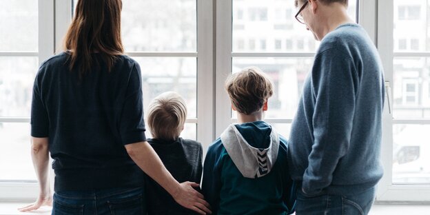 Familie von hinten am Fenster Familie von hinten am Fenster