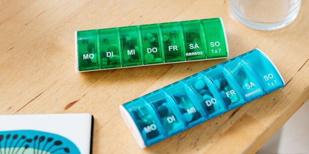 Plastikbehälter mit Tabletten, nach Wochentagen sortiert Plastikbehälter mit Tabletten, nach Wochentagen sortiert
